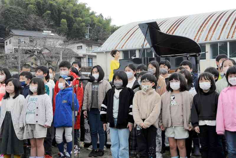 熊本豪雨で被災し修復された渡小の「希望のピアノ」を演奏する西村由紀江さん（奥）と合唱する同小の児童ら＝球磨村