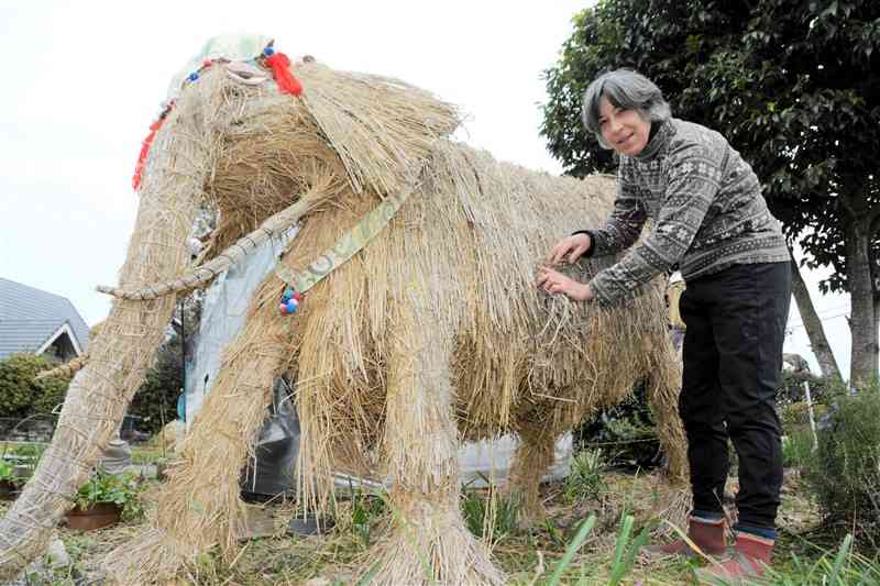 自宅の庭に稲わらや廃材でゾウなどの作品を作った丹部カレンさん＝熊本市南区