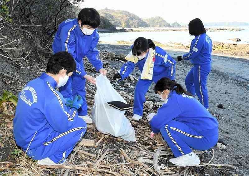 茂串海岸でごみを拾い集める牛深中の3年生＝天草市