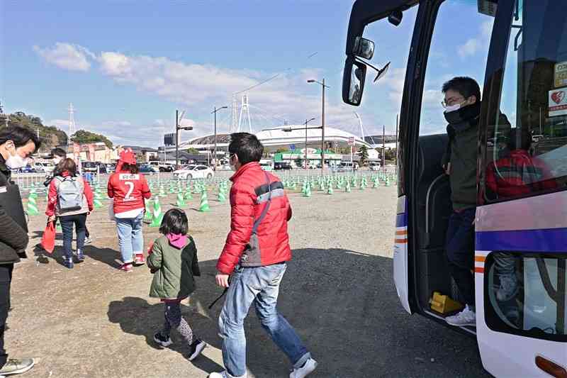 パークアンドバスライドを利用し、えがお健康スタジアム（奥）へ向かう観客＝2月26日、熊本市東区（谷川剛）