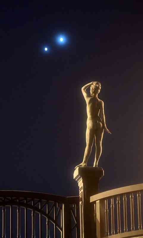 長六橋の裸婦像の頭上に並んで輝く金星（右）と木星＝2日午後7時10分ごろ、熊本市中央区（ソフトフィルター使用）