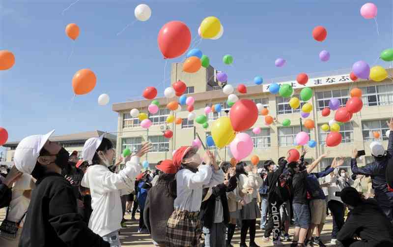 カウントダウンに合わせて風船を一斉に放つ秋津小の児童ら＝熊本市東区