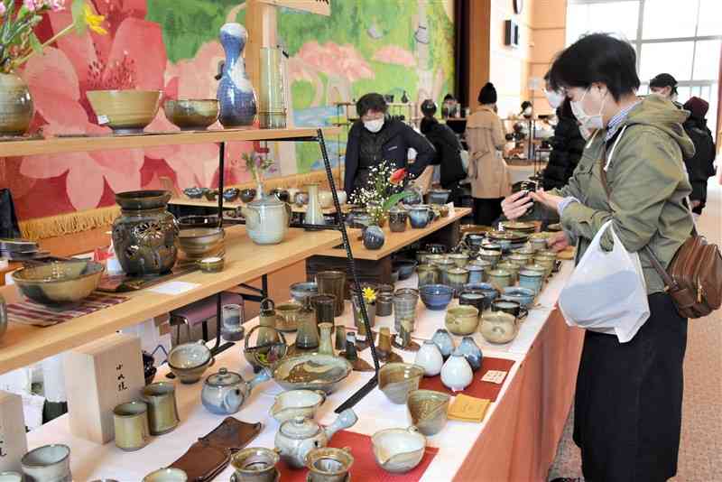 20窯元の作品が並ぶ「陶器・梅まつり」で好みの品を選ぶ来場者＝南関町