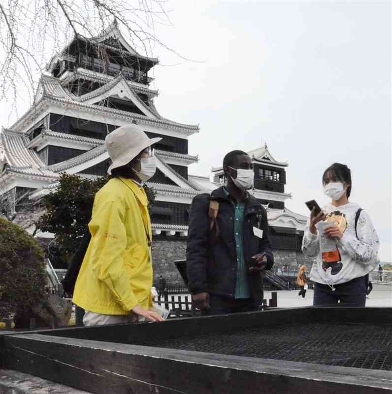 熊本城の歴史などについて観光ボランティアから解説を聞く留学生ら＝熊本市中央区