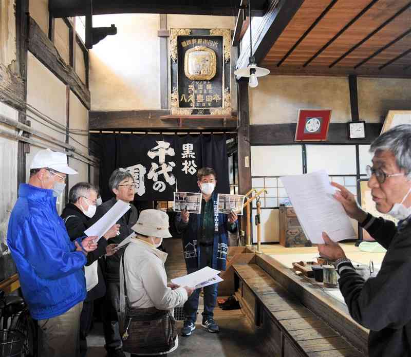 本田家住宅の見学会で、資料を手に建物内を見て回る参加者ら＝山鹿市