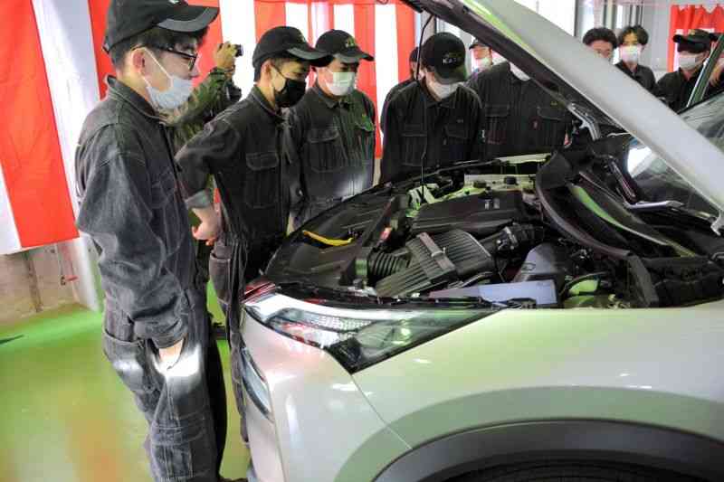 教材車として貸与された新型エクストレイルのエンジンルームをのぞき込む生徒たち＝10日、熊本市中央区