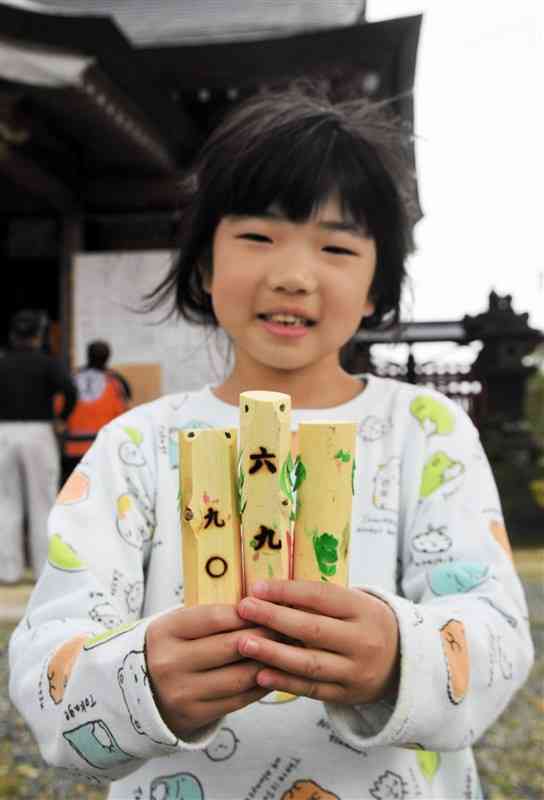 南島菅原神社の「うそがえ神事」に使われる木細工「ウソ」。くじ引き用の番号が焼き印してある＝山鹿市