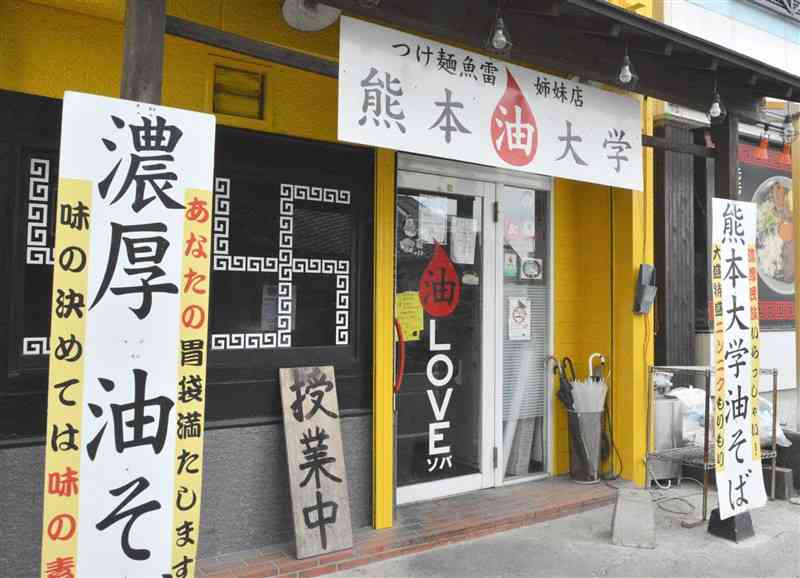 記者が学生時代から通う「熊本油大学」。入り口左の看板が「授業中」になると開店だ＝熊本市中央区