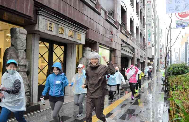 雨の中、県のアンテナショップ「銀座熊本館」を出発するランナー＝18日、東京・銀座