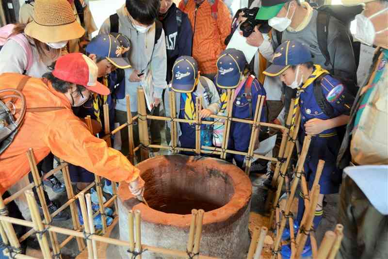 武家屋敷の井戸の説明を受ける参加者＝宇土市