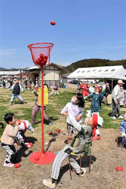 かかしに交じって、玉入れを楽しむ子どもたち＝19日、天草市宮地岳町の道の駅「宮地岳かかしの里」広場