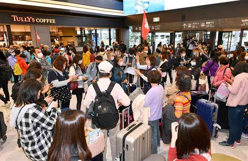 台湾からの旅行者でにぎわう新旅客ターミナルビルの到着ロビー＝23日午前10時半ごろ、益城町の熊本空港（鹿本成人）