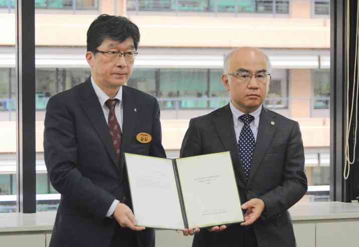 県立高校入学者選抜制度検討委員会の八幡英幸会長（右）から提言書を受け取った白石伸一県教育長＝24日、県庁