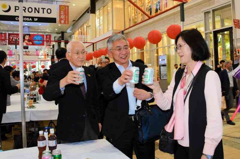 台湾との交流を歓迎し、台湾ビールで乾杯する中心商店街関係者ら＝熊本市中央区