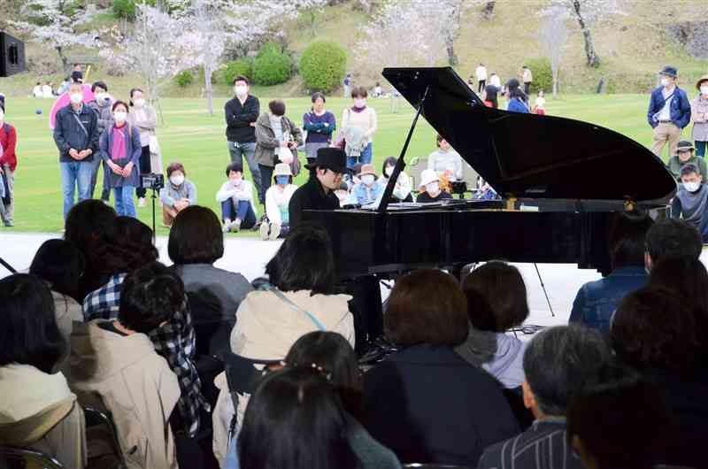 菊池市への熱い思いを込めピアノを弾く菊池亮太さん＝同市