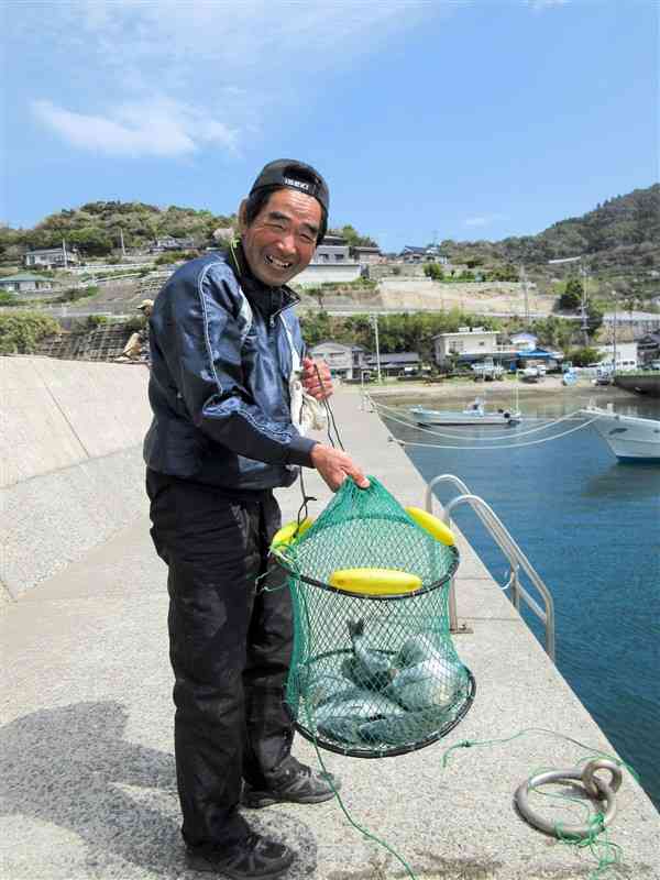 メイタの釣果を見せ満面の笑顔を見せる中村和宝さん＝津奈木町の福浜漁港