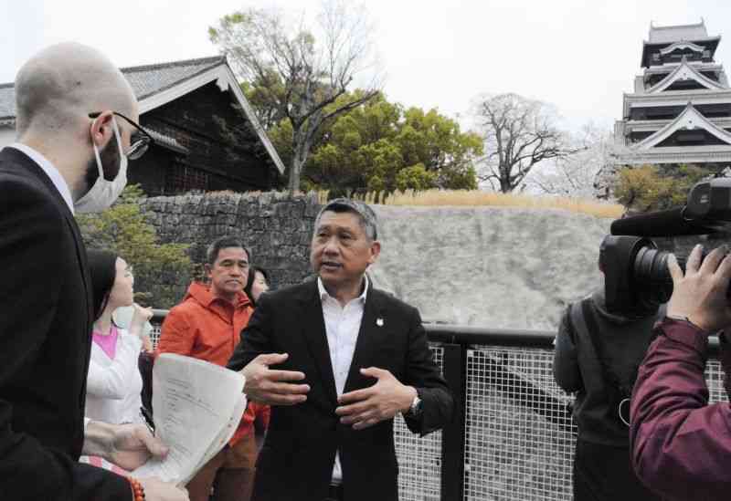 熊本市職員から熊本城について説明を受ける李益輝会長（中央）ら＝30日、熊本市中央区