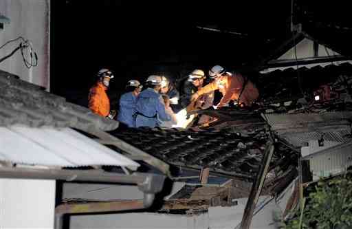 地震で倒壊した家で救助活動する熊本市消防局員ら＝４月１４日午後１１時５９分、益城町（岩崎健示）