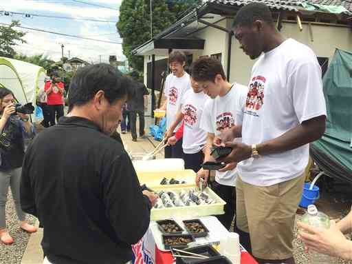 公民館に避難する被災者たちに、おにぎりや豚汁の炊き出しをする熊本ヴォルターズの選手たち＝11日、益城町