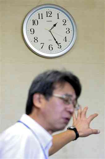熊本地震の本震があった「午前１時２５分」で止まったままの時計。手前は現社長の二子石隆一さん＝７月１５日、益城町のグランメッセ熊本（岩崎健示）
