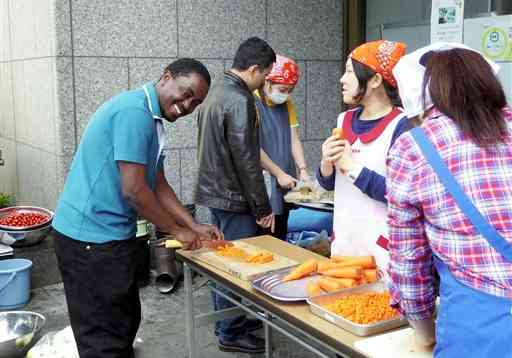 外国人避難者（左）も協力した市民団体による炊き出し＝２０１６年４月２９日、熊本市国際交流会館（市国際交流振興事業団提供）