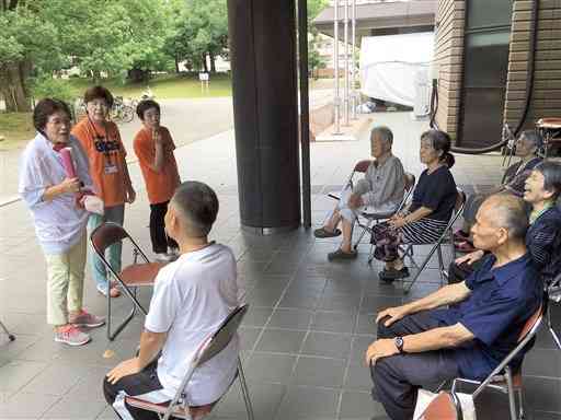 熊本市総合体育館の玄関前で「口の体操」の指導をする土屋裕子さん（左端）ら＝２０１６年７月４日、熊本市中央区