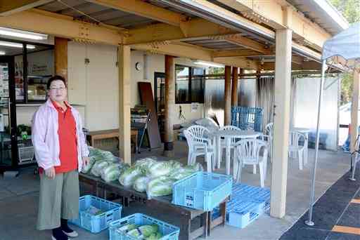熊本地震の後、生産者が持ち込んだ野菜などを販売した店舗の軒先に立つ河原君代さん＝１１月１５日、嘉島町のＪＡかみましき・とれたて市場嘉島店
