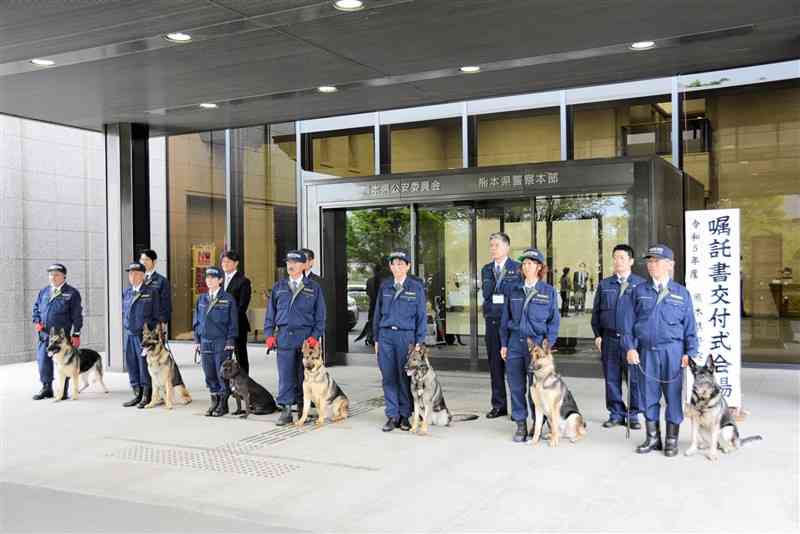 記念撮影に臨む嘱託警察犬と指導士ら＝5日、県警本部