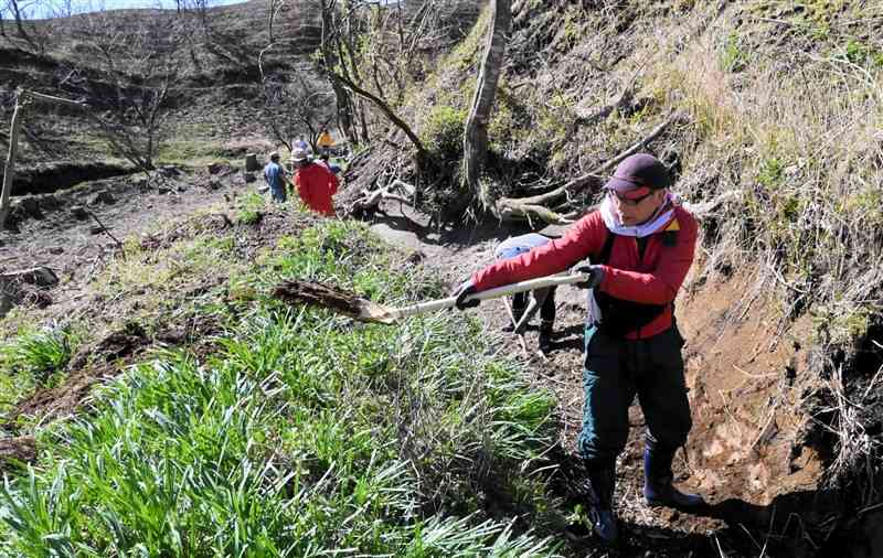 水路にたまった土をスコップでかき出すボランティアら＝産山村