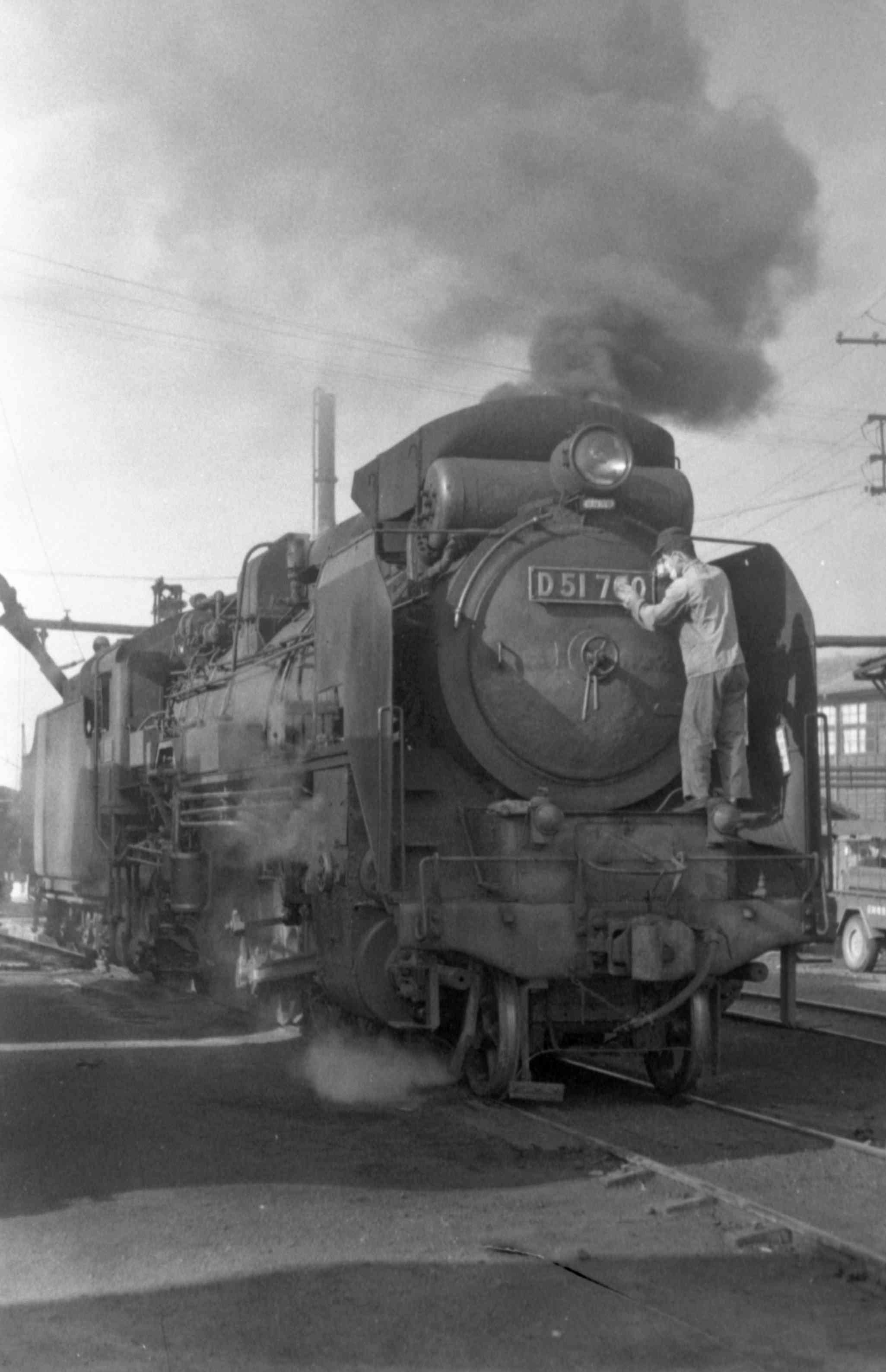 D51型蒸気機関車の車体を磨く機関士＝1967年、人吉市の国鉄人吉機関区