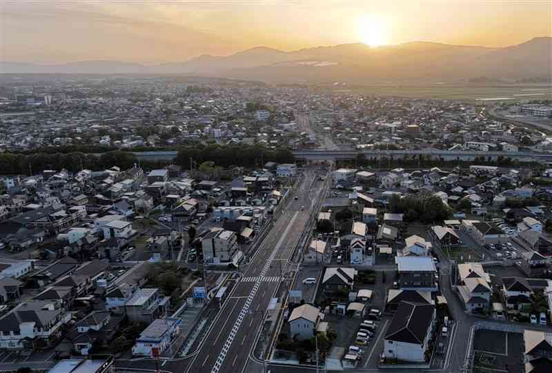 14日で熊本地震から7年を迎える益城町。4車線化の一部供用が始まった同町広崎付近の道路延長上に朝日が昇った＝13日午前6時10分ごろ、（谷川剛・小野宏明、ドローン撮影）