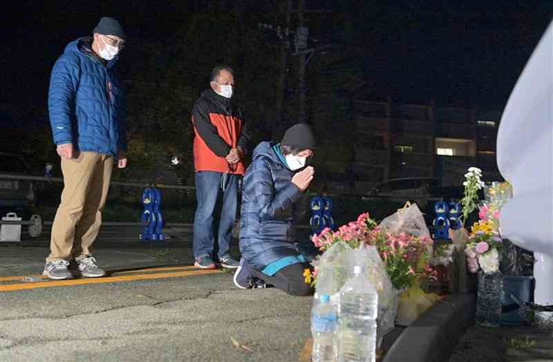 大和晃さんが犠牲となった阿蘇大橋の近くで、手を合わせる母忍さん。左から父卓也さん、忍さんの兄本郷征美さん＝16日午前1時25分過ぎ、南阿蘇村（上杉勇太）