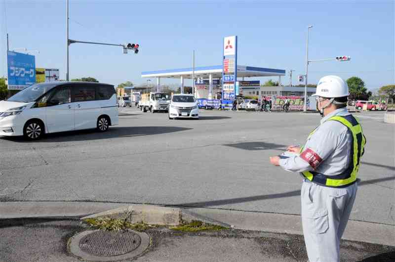 セミコンテクノパーク方面へ向かう右折車両の数を計測する菊陽町職員＝同町