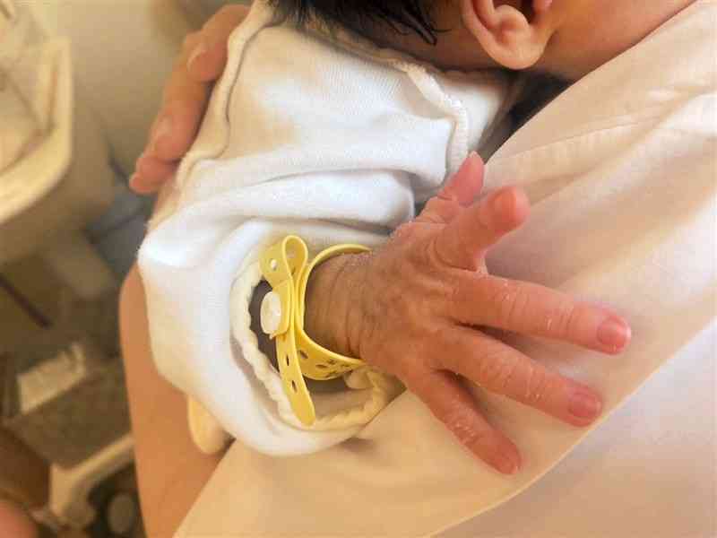 内密出産で産んだ赤ちゃんを抱くカオリさん（仮名）＝熊本市西区の慈恵病院