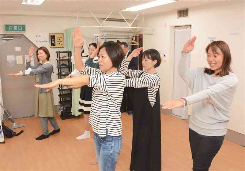 安達和美さん（右から３人目）の手本で、山鹿灯籠踊りの振り付けを学ぶ「東京よへほ会」のメンバーら＝東京都新宿区