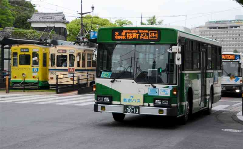 熊本市中心部を走るバスと市電。乗客数がコロナ前の8割程度まで回復してきた＝20日、同市