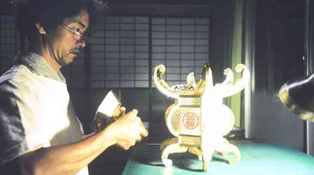 特別試写会で披露された映画「骨なし灯籠」。主人公の男性が山鹿灯籠の制作に取り組む場面