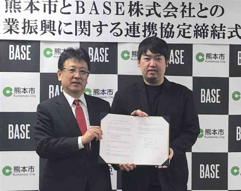 中小企業のECサイト活用支援に向け、熊本市と連携協定を結んだBASEの鶴岡裕太代表（右）＝25日、熊本市