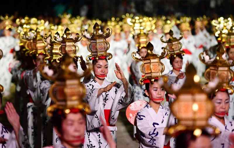 「千人灯籠踊り」で、金灯籠を頭に載せて優雅な舞を披露する浴衣姿の女性たち＝2019年8月、山鹿市の山鹿小グラウンド（小野宏明）