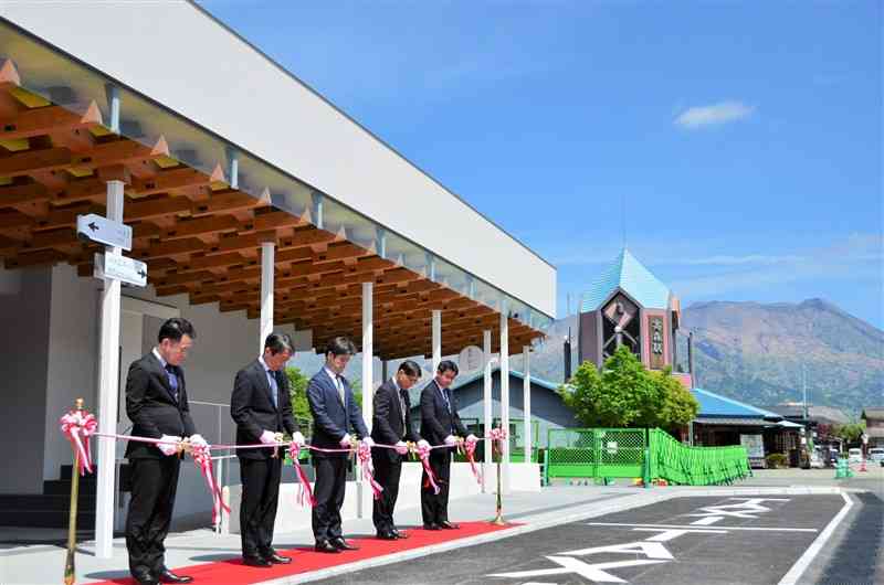 高森駅の落成式でテープカットする関係者ら。右奥に見えるのは阿蘇五岳＝高森町