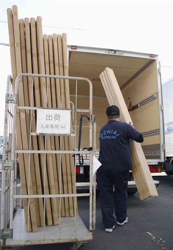 商品をトラックに積みこむ運転手＝2019年5月、埼玉県