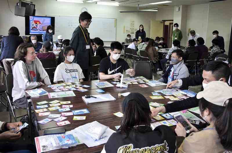 ゲームを通して災害時の行動について考える外国人の参加者ら＝長洲町
