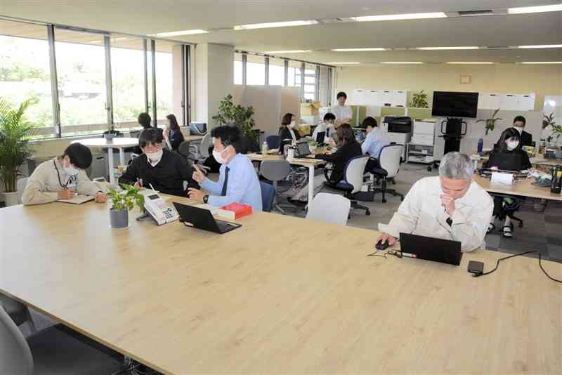 熊本市が新設の森の都推進部に導入したフリーアドレスの執務スペース。大型テーブルやウェブ会議用ブースを設けた＝市役所
