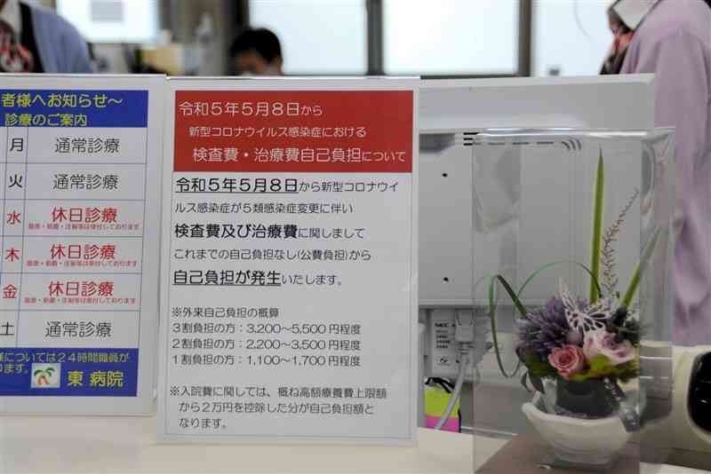 病院窓口で新型コロナウイルス感染症の治療費や検査費を知らせる掲示。5類移行後は自己負担が発生する＝熊本市南区の東病院