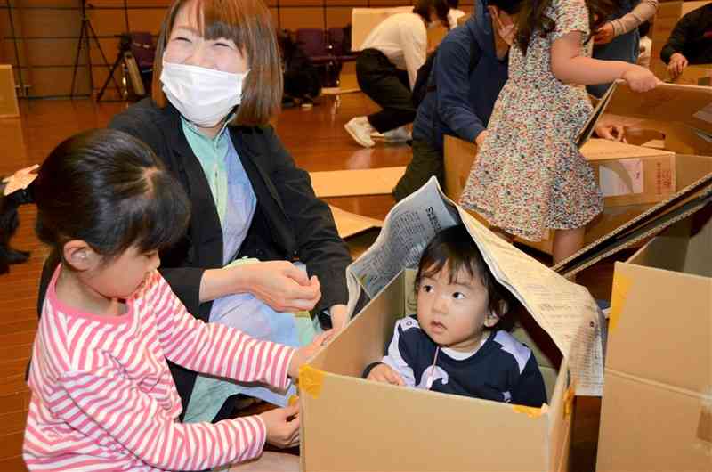 段ボールや新聞紙で家を作る親子＝熊本市西区