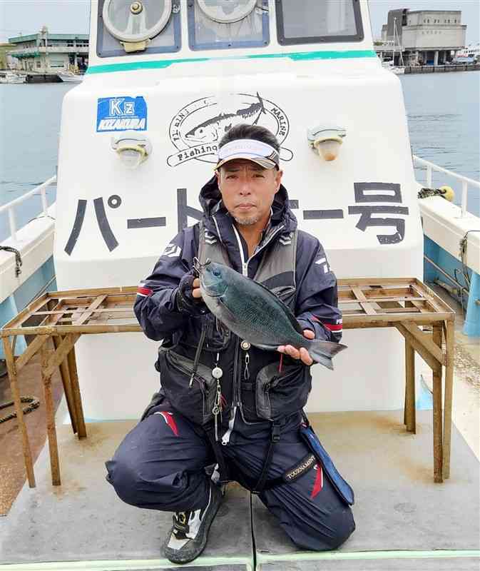 浅ダナで捉えた良型クロを手にする天川昌和さん＝天草市牛深町の沖の平瀬