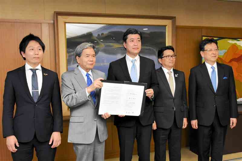 地下水涵養推進に関する協定を締結したJASMの堀田祐一社長（中央）ら＝16日、県庁