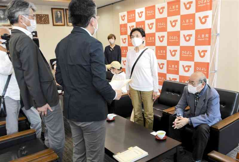 人吉市の災害公営住宅建設に反対する要望書を提出する田代隆子代表（右から2人目）＝同市役所