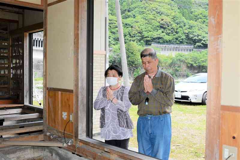 熊本豪雨で行方不明となった城幸惠さん方で手を合わせるおいの城文博さんと妻の裕子さん＝17日、芦北町