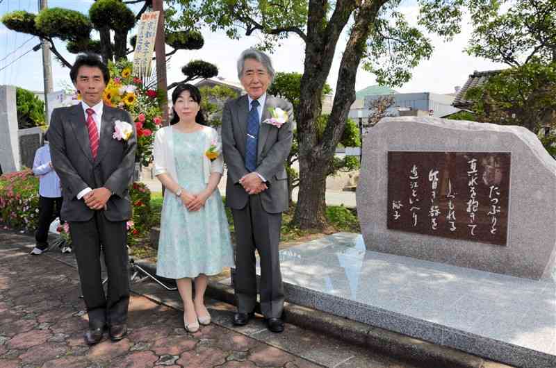 河野裕子さんの歌碑の完成を喜ぶ、いずれも歌人で夫の永田和宏さん（右）と長女紅さん（中央）、長男の淳さん＝御船町